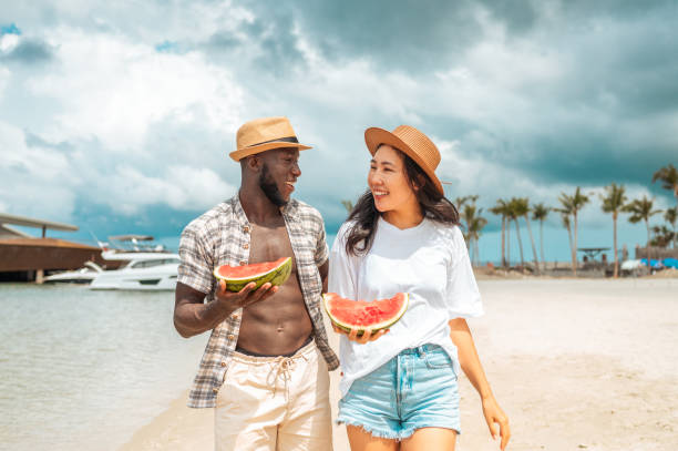 istock Joyful Interracial Couple Sharing Watermelon at the Beach 2173988626