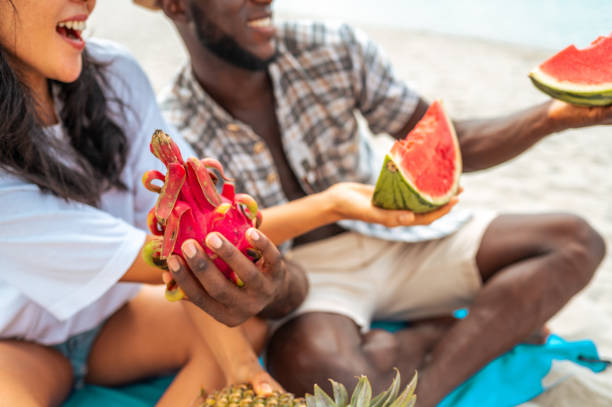 istock Interracial Couple Savoring Watermelon on Beach Retreat 2173988632