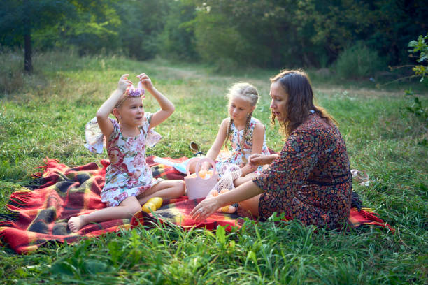 istock two little girls and mom paint eggs at easter picnic 2173992413