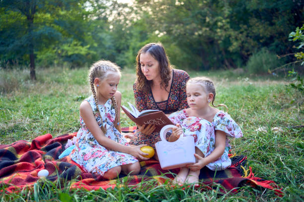 istock a mother and her two daughters read the holy bible and pray at an Easter picnic 2173992704
