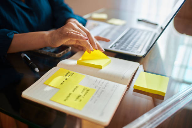 istock Focused Woman Working on Laptop with Yellow Sticky Notes 2173994756