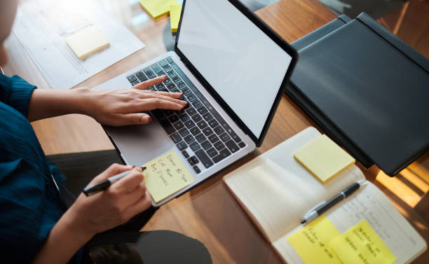 istock Focused Woman Working on Laptop with Yellow Sticky Notes 2173994764