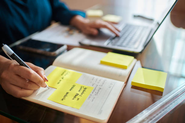 istock Focused Woman Working on Laptop with Yellow Sticky Notes 2173994782