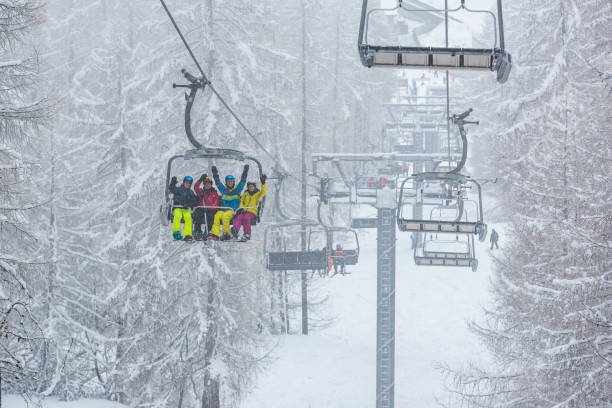 istock Friends going up ski lift on snowy mountain 2173998227