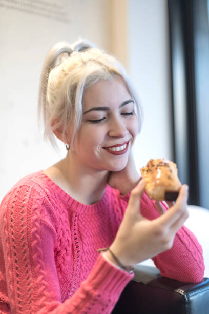 istock Young woman enjoying a pastry in a cozy setting 2173999078