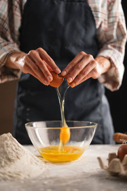 istock close-up of female hands without a face throws an egg into a bowl, holds the shells in her hands 2174000388