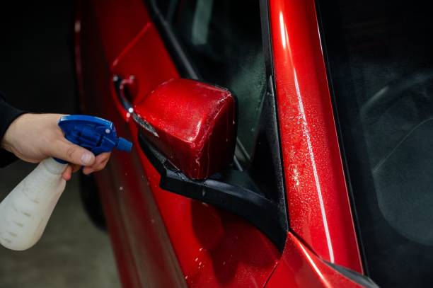 istock A technician sprays water before applying protective vinyl film to a car. 2174004497