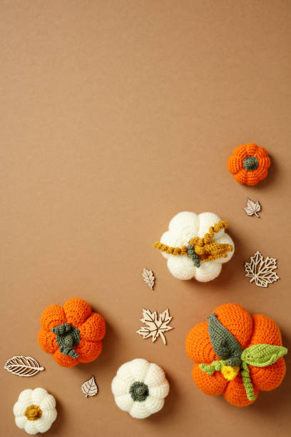 istock Handcrafted crochet pumpkins on a warm brown backdrop. Perfect for DIY project themes, crafting blogs 2174007948