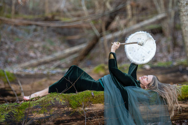 istock Woman playing a drum in a forest. Shallow depth of feld 2174008279