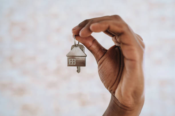 istock hand holding key to new house 2174014825