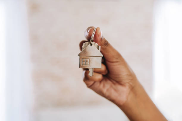 istock hand holding key to new house 2174014925