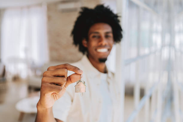 istock holding house key smiling looking at camera 2174015118
