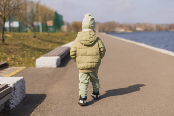 istock Child boy walking on the street alone. 2174022360