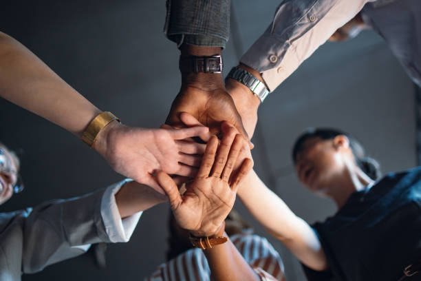 istock Diverse Group of People Joining Hands in Unity 2174029666