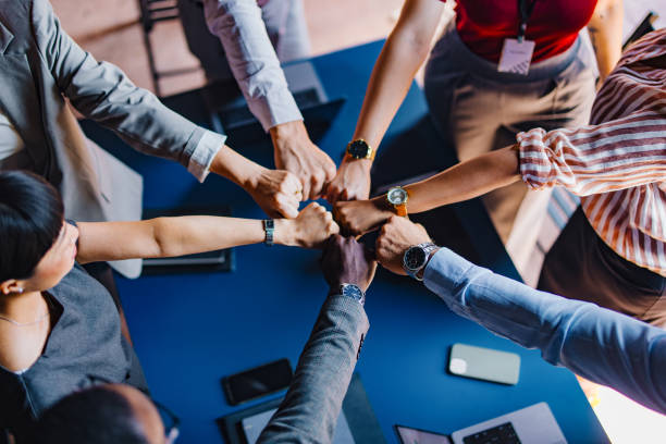 istock Diverse Group of Professionals Joining Hands in Unity 2174029699