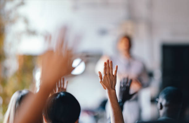 istock Diverse Audience Raising Hands at Business Presentation 2174029814