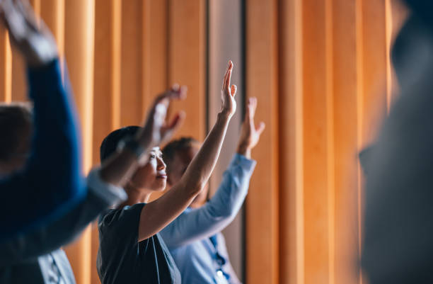 istock Enthusiastic Participants Raising Hands at a Business Workshop 2174029820