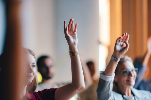 istock Engaged Audience in Business Meeting with Raised Hands 2174029840