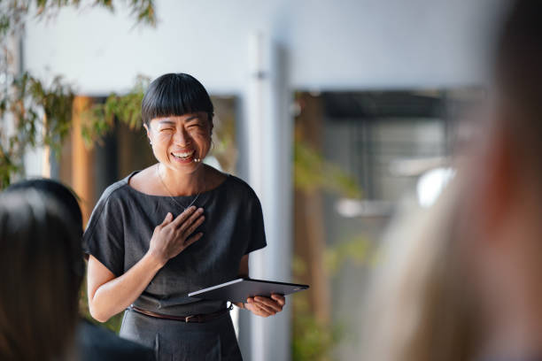 istock Smiling Professional Woman Giving a Presentation with a Tablet 2174029845