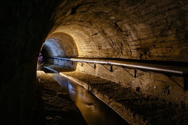 istock Underground vaulted urban sewer tunnel with dirty sewage 2174032079