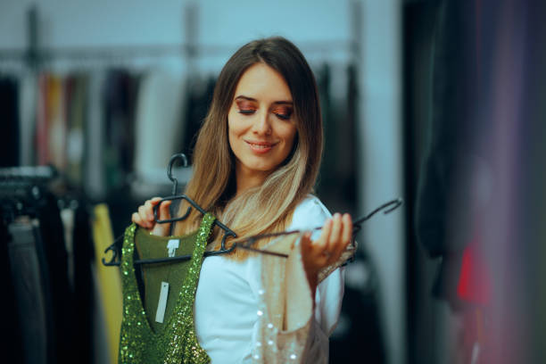 istock Happy Woman Comparing Two Sparkling Party Dresses 2174034935