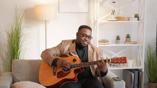 istock Guitar inspiration song playing man couch home 2174040101