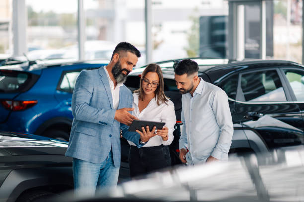 istock Dealer uses tablet to enhance couple's car purchasing process. 2174040336