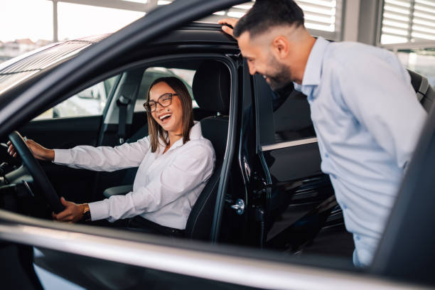 istock Woman driver enjoys discussion about features with salesman. 2174040342