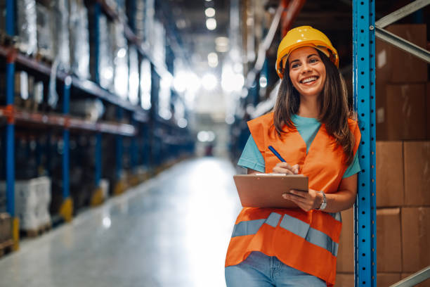 istock Cheerful female worker records data with clipboard in warehouse. 2174040351