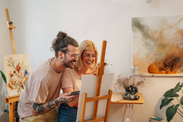 Romantic happy artistic couple at creative art studio painting on easel