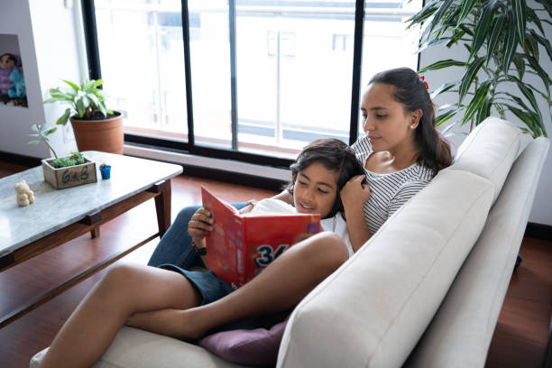 istock Mom reading a book with her son at home without technology or electronic devices inside her home during the day 2174042421