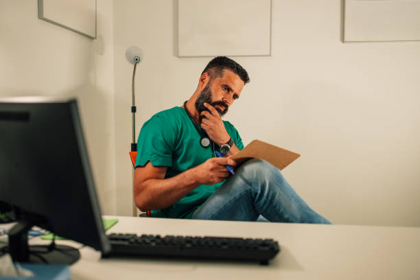 Medical professional thinking while holding clipboard in office.