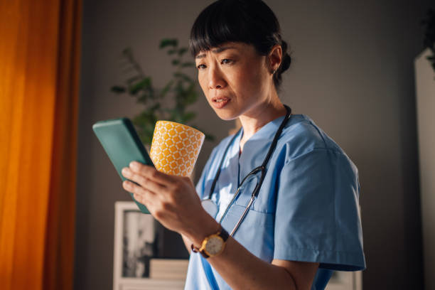 istock Asian nurse surprised by message on phone drinking morning tea 2174042680