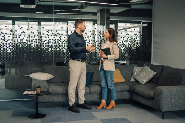 istock Full length of two managers at modern office discussing project. 2174042697