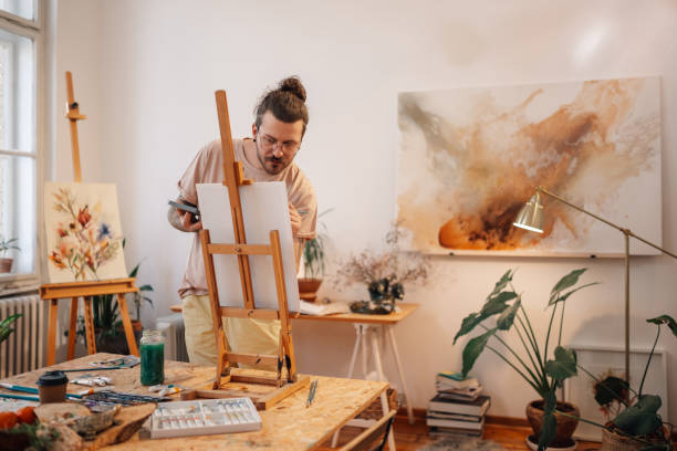 istock Precise skilled young artist painting on easel at creative art studio. 2174042722
