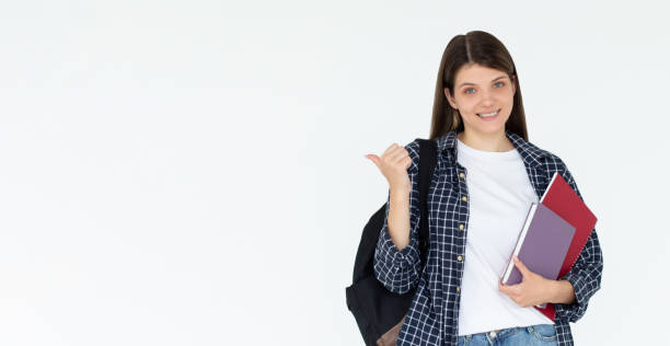 istock Hey look. Smiling pretty female model pointing fingers left at empty space and inviting to check it out, showing advertisement on white background. Girl with notepads in hands. 2174048740