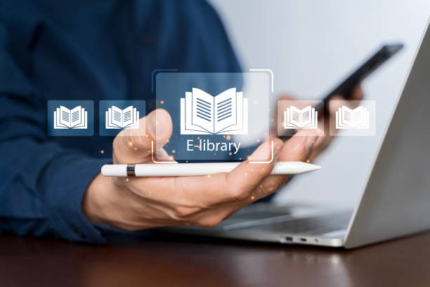 istock E-library concept. Person use laptop with virtual E-book icons for electronic books online 2174049016