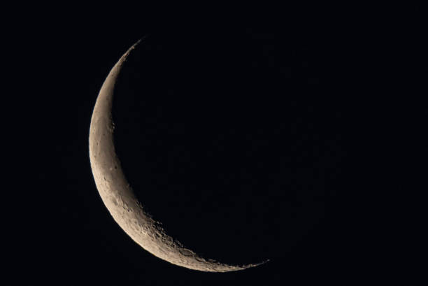 istock Bright partial moon photographed with craters in view on a black background. 2174051459