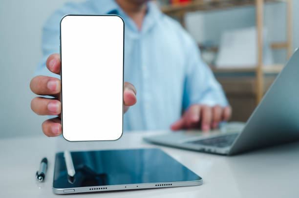 istock Businessman hand holding  holding smartphone with white empty screen in hand, Smartphone mockup for online shopping, Booking and banking concept, Online education or online business with copy space. 2174055328