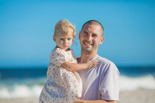 Happy Father carrying little doughter at beach