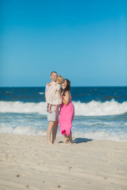 istock Happy parents carrying little doughter at beach 2174059551