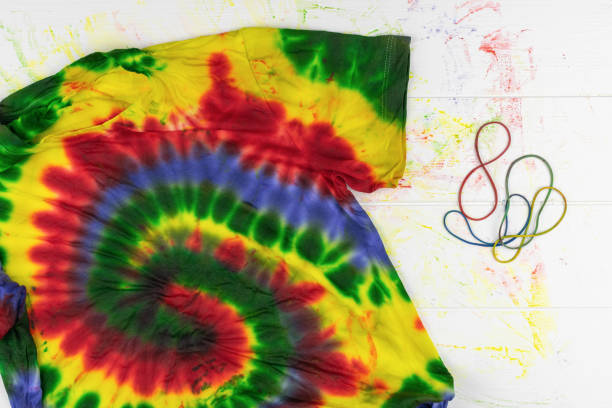 istock Colorful Tie-Dye T-Shirt with Swirl Pattern and Elastic Bands on White Background 2174063868