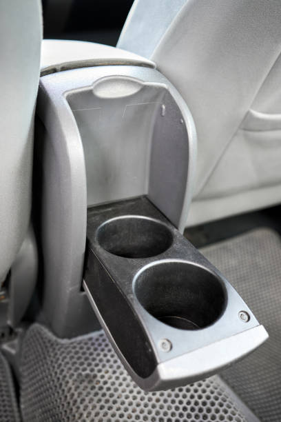 Cup holder modern electric hybrid car interior element. Grey leather rear passenger seat console with details, closeup shot.