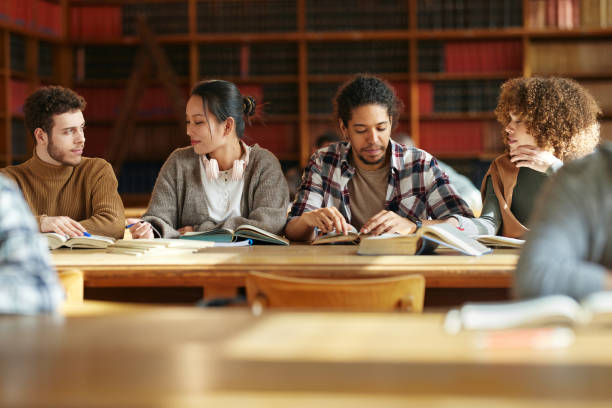 istock Group of university students studying in team at library. 2174084005