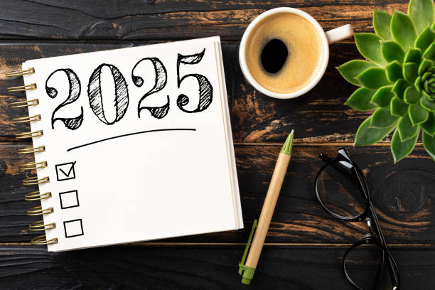 istock New year resolutions 2025 on desk. 2025 resolutions list with notebook, coffee cup on wooden table. Goals, resolutions, plan, action, checklist concept. New Year 2025 template 2174086015