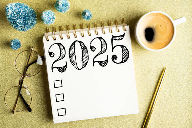 istock 2025 New year resolutions on desk. 2025 goals list with notebook, coffee cup, festive decorations on golden background. Resolutions, plan, goals, checklist, idea concept. New Year 2025 resolutions 2174086074
