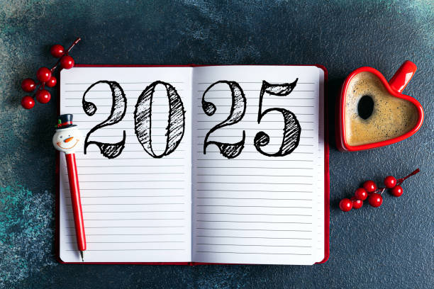 New year resolutions 2025 on desk. 2025 goals list with notebook, coffee cup on blue table. Resolutions, plan, goals, action, checklist, idea concept. New Year 2025 resolutions