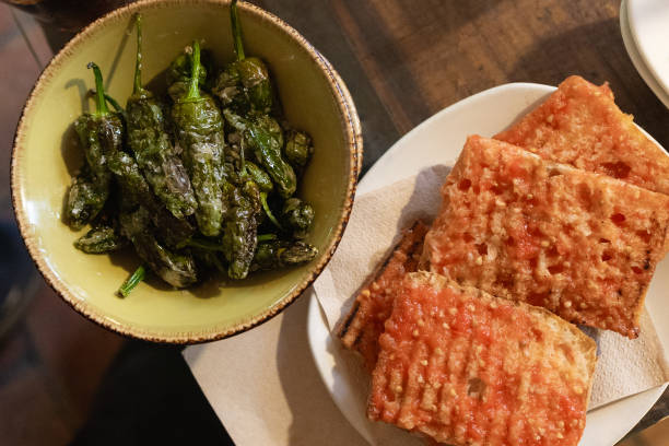Salty padron peppers and toast with tomato sauce. Typical Spanish tapas.