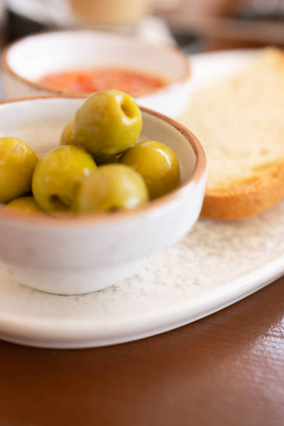Toast with a side of tomato sauce and olives.