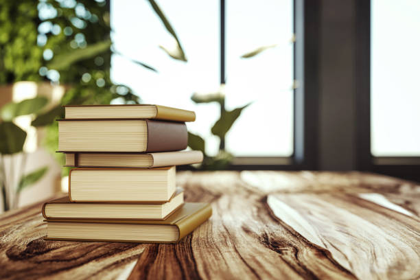 istock Stack of hardcover books on a wooden table in a sunlit room. 3D Rendering 2174090638